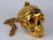 Appraisal: A gold plated hinged brass skull box on heavy chain