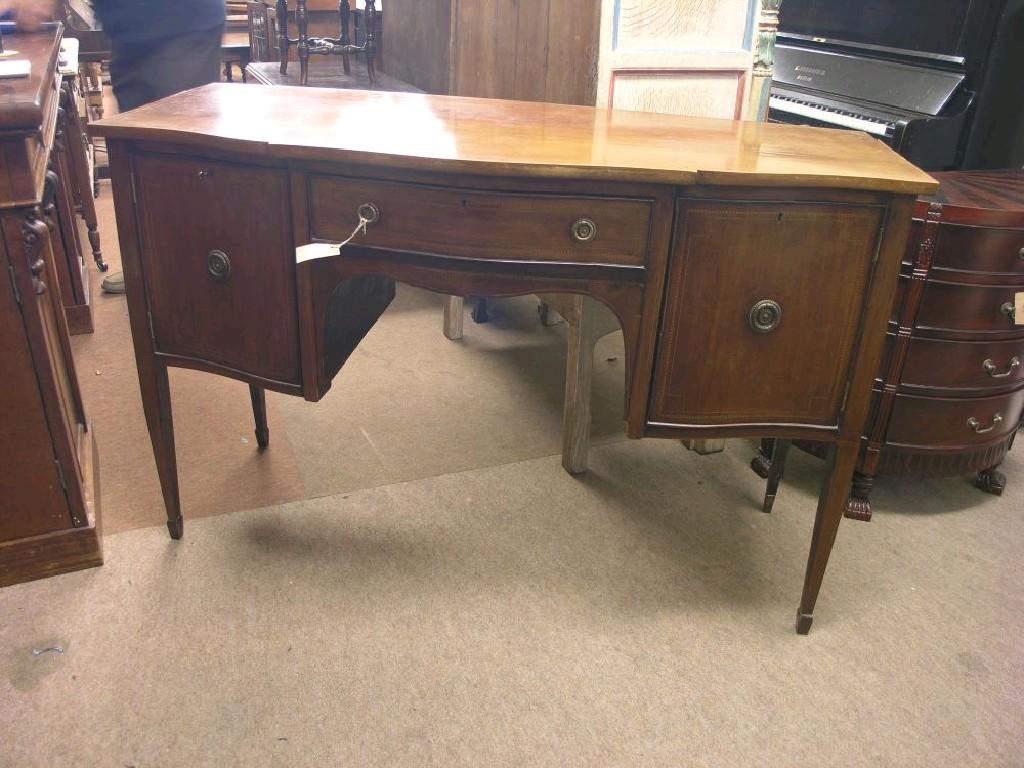 Appraisal: An Edwardian inlaid mahogany sideboard serpentine-fronted with central drawer flanked