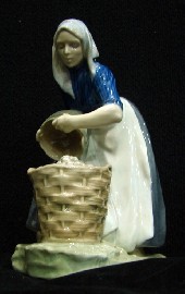 Appraisal: A Royal Copenhagen figure of a farming lady decanting fruit