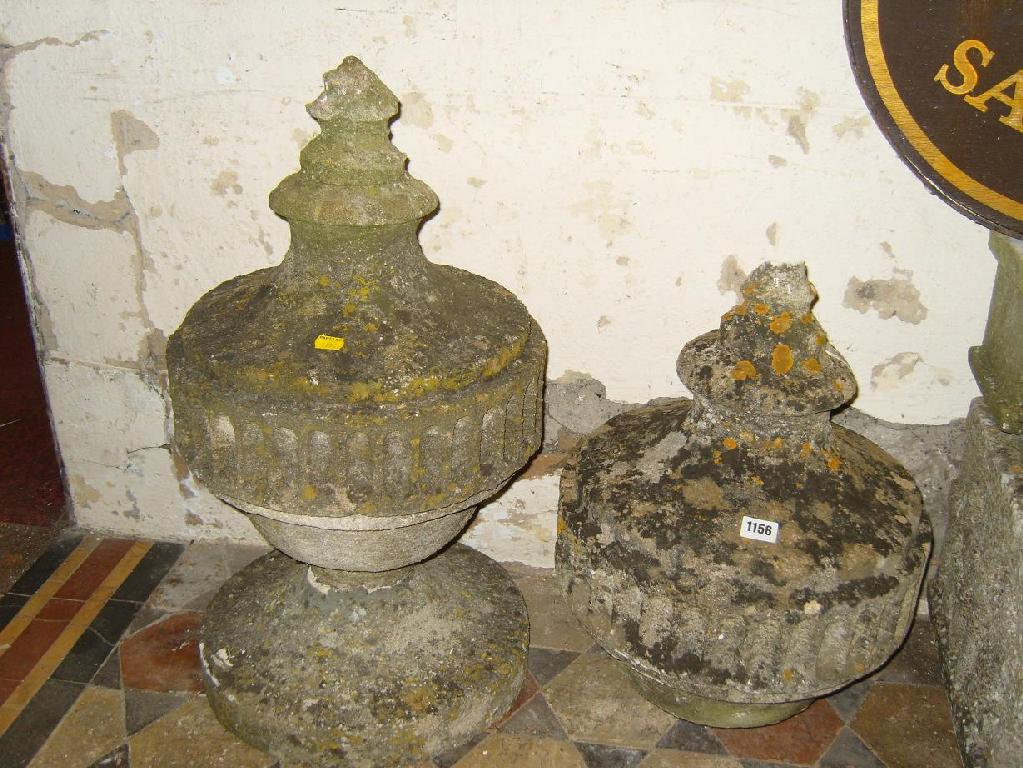 Appraisal: Two Victorian stone urns with turned finials and carved frieze