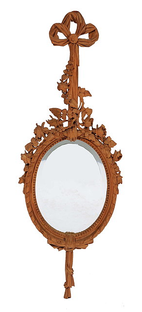 Appraisal: A CARVED PINE FRAME HANGING WALL MIRROR with bevelled glass