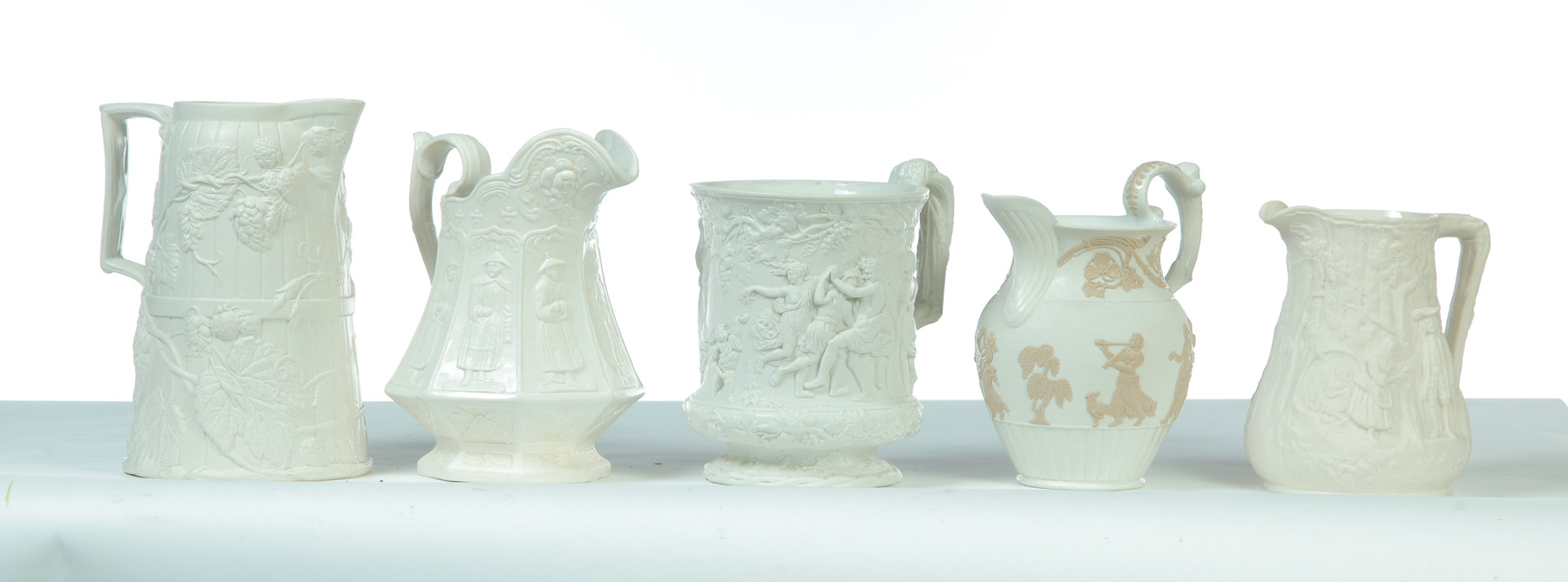 Appraisal: FIVE RELIEF MOLDED WHITE PITCHERS England mid th century Various