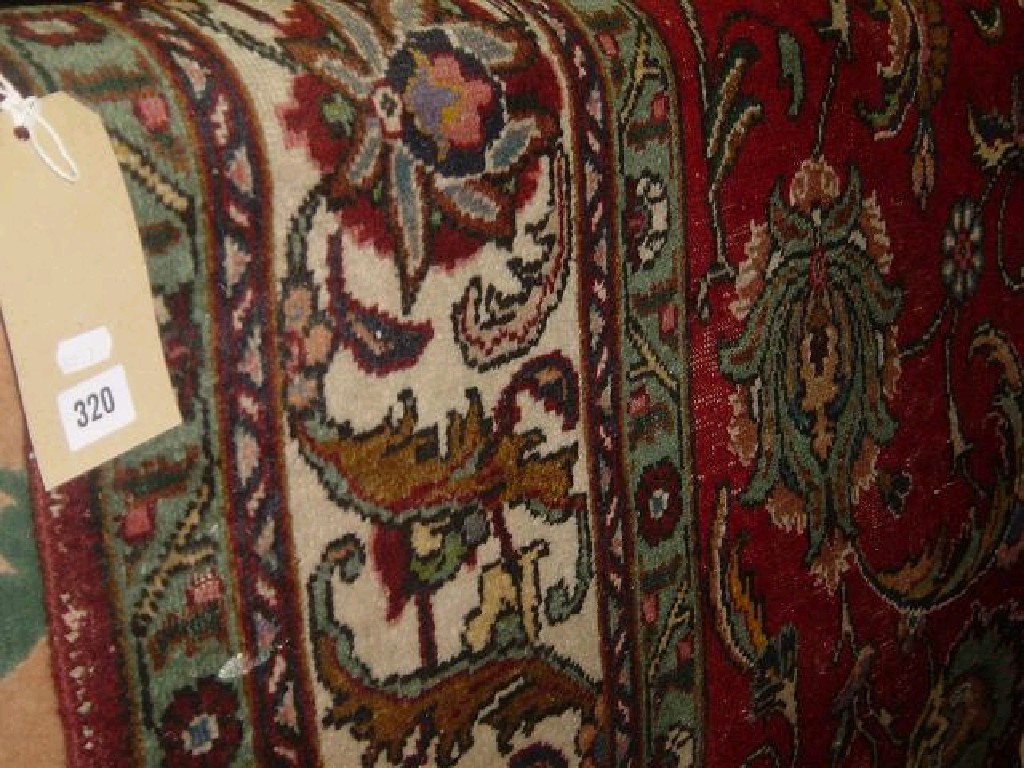 Appraisal: A red ground wool rug with stylised floral decoration in