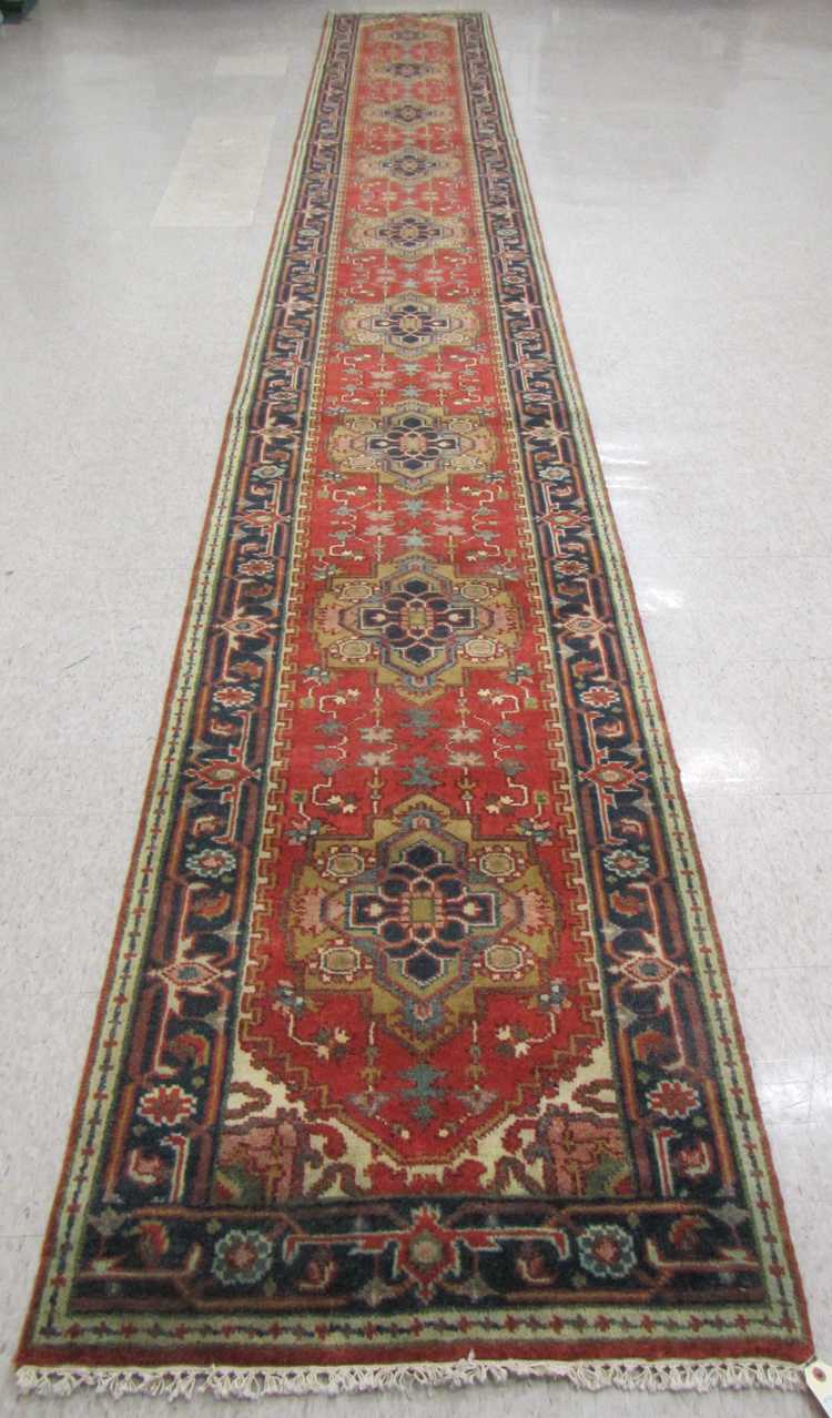 Appraisal: HAND KNOTTED ORIENTAL LONG RUG Indo-Persian featuring nine geometric medallions