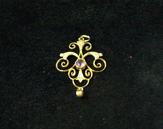 Appraisal: A ct gold pendant of scrolling form set a central