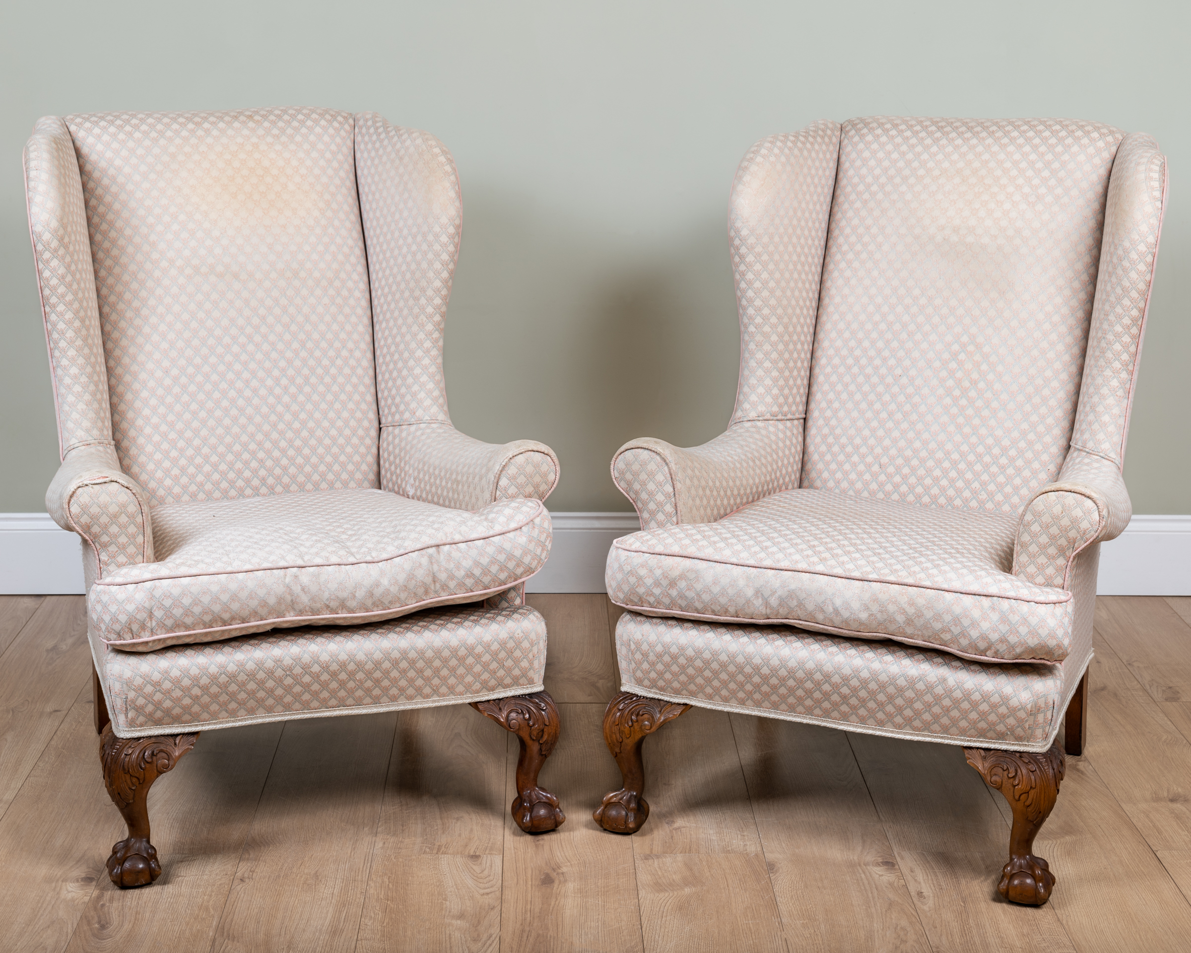 Appraisal: A pair of George III-style walnut wingback armchairs the legs