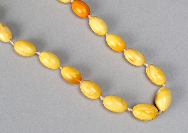 Appraisal: A GRADUATED YELLOW AMBER OVAL BEADED NECKLACE largest bead mm