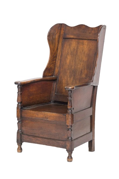 Appraisal: A mid th century panelled oak wingback lambing chair on