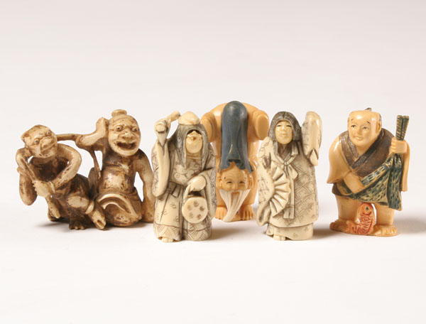 Appraisal: Carved elephant ivory netsukes and figures pair rotating face figures