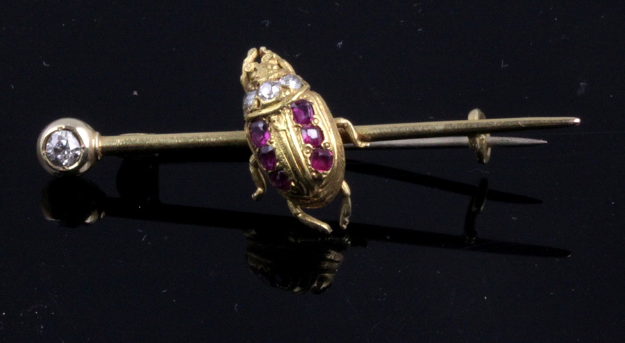 Appraisal: A tie pin with diamond terminal and centred by a