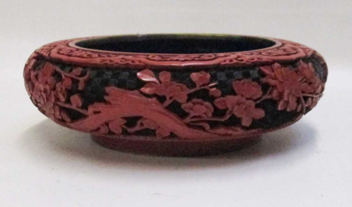 Appraisal: CHINESE CINNABAR STYLE BOWL having red raised carving and black