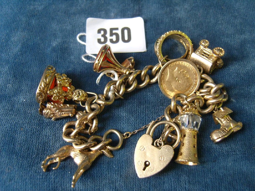 Appraisal: A ct gold charm bracelet set with various charms including