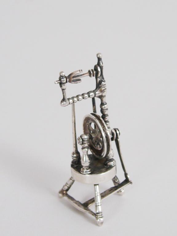 Appraisal: A miniature silver Spinning Wheel on three turned supports