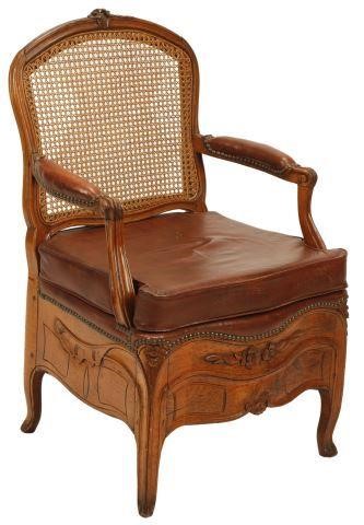 Appraisal: French Provincial caned commode chair th c with leather cushion