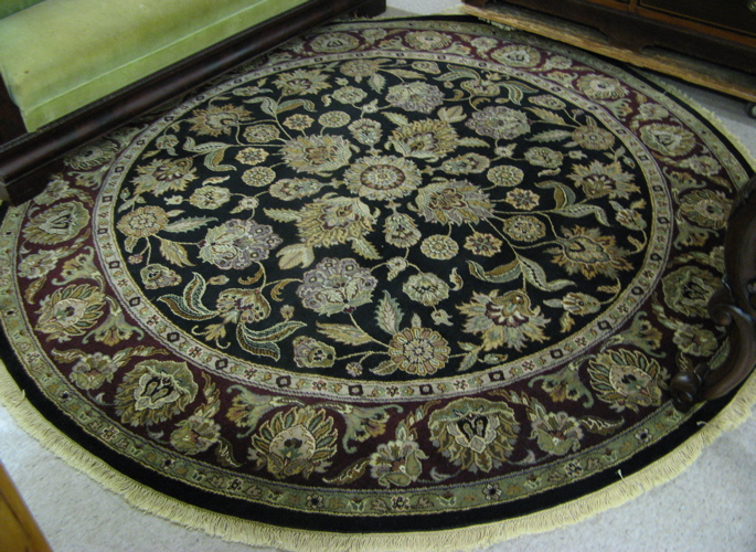 Appraisal: A ROUND ORIENTAL ACCENT CARPET Persian Kashan design overall floral