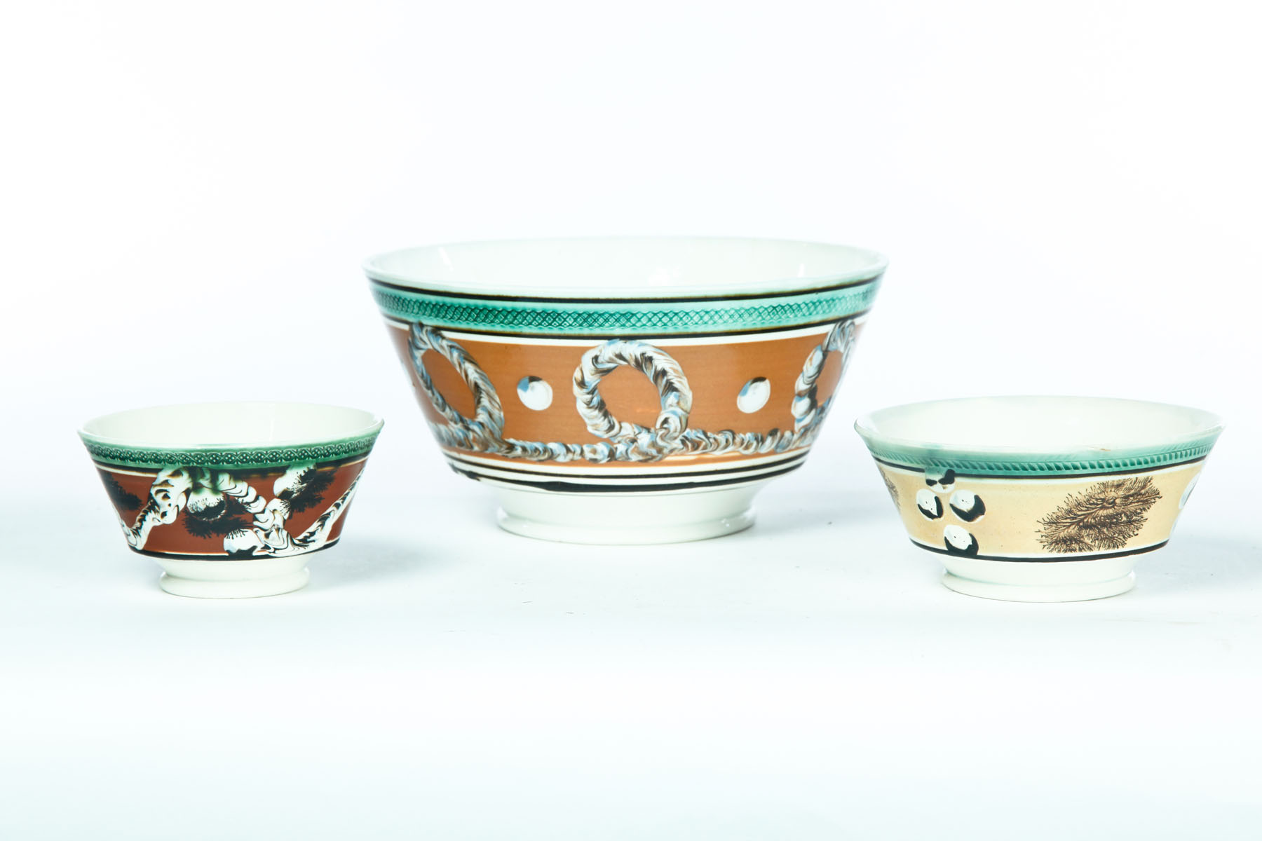 Appraisal: THREE MOCHA BOWLS England nd quarter- th century Tooled rims