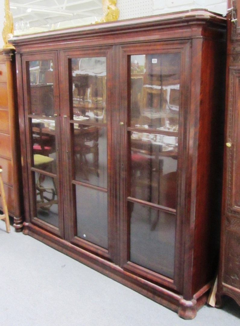 Appraisal: A th century Continental mahogany floor standing three door bookcase