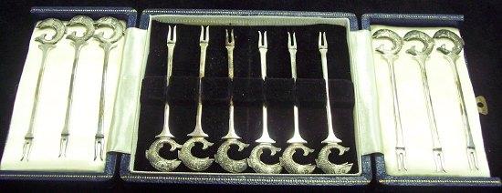 Appraisal: A set of twelve cocktail sticks with jumping fish finials