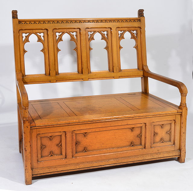 Appraisal: A VICTORIAN LIGHT OAK GOTHIC REVIVAL SETTLE with scrolling acanthus