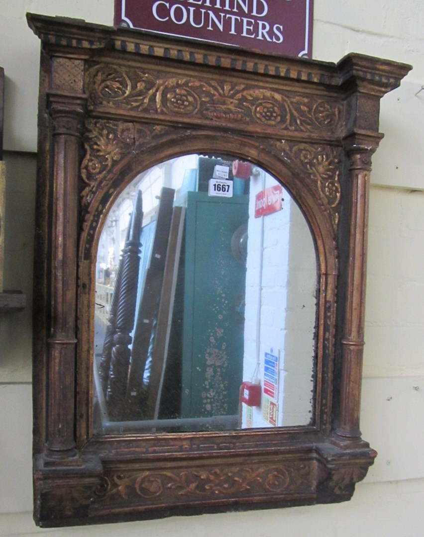 Appraisal: A giltwood carved wall mirror th century with broken arch