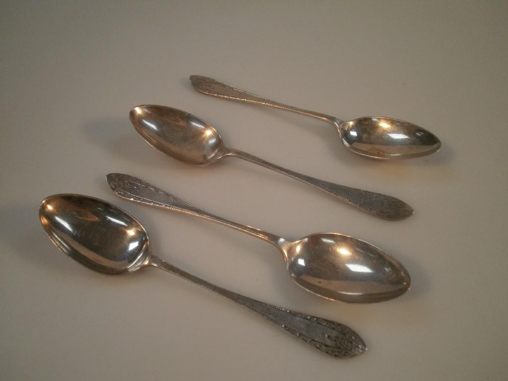 Appraisal: Four George V silver teaspoons with engraved handles Sheffield oz