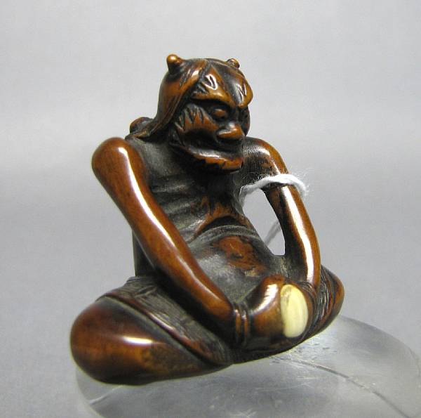 Appraisal: A stained boxwood and ivory figural netsuke th Century Depicting