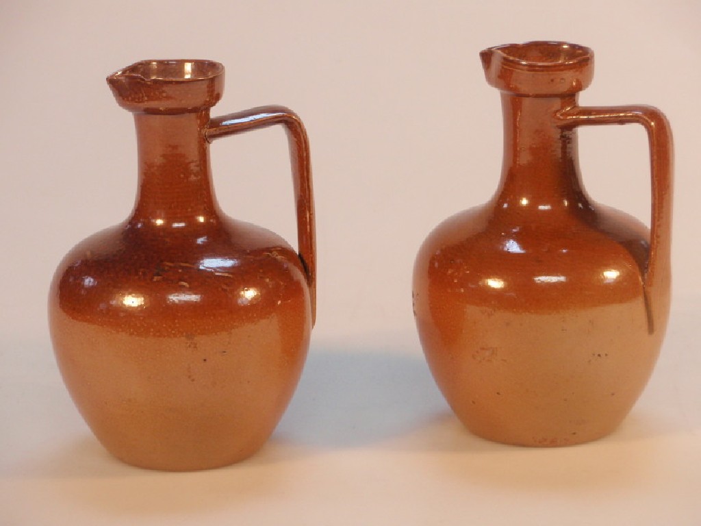 Appraisal: A pair of Lambeth Doulton stoneware ovoid ewers cm high