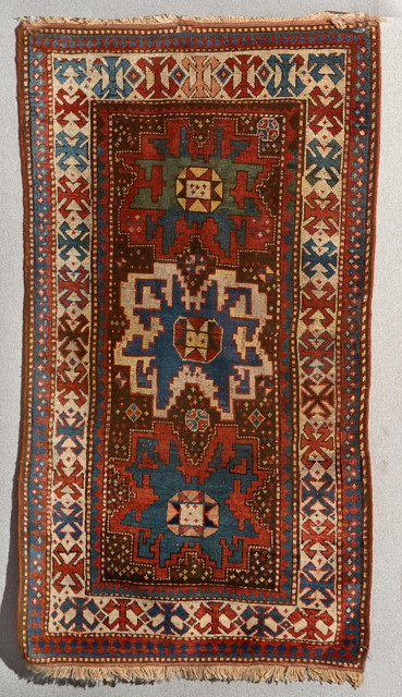 Appraisal: A CAUCASIAN TRIBAL RUG with polychrome triple medallion and hooked