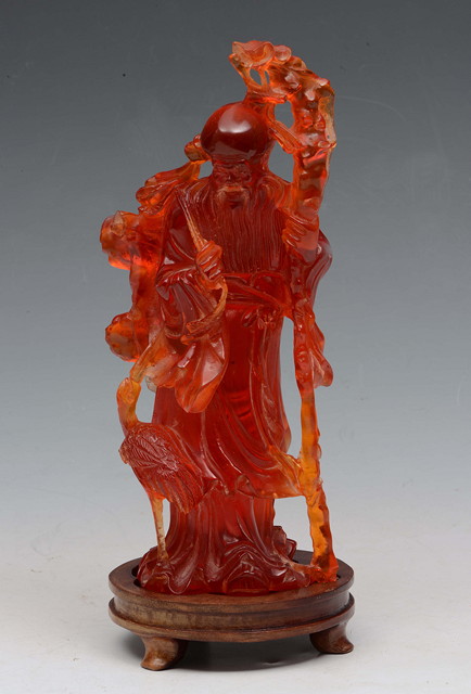 Appraisal: A CHINESE AMBER CARVED MODEL OF LAO TSE holding a