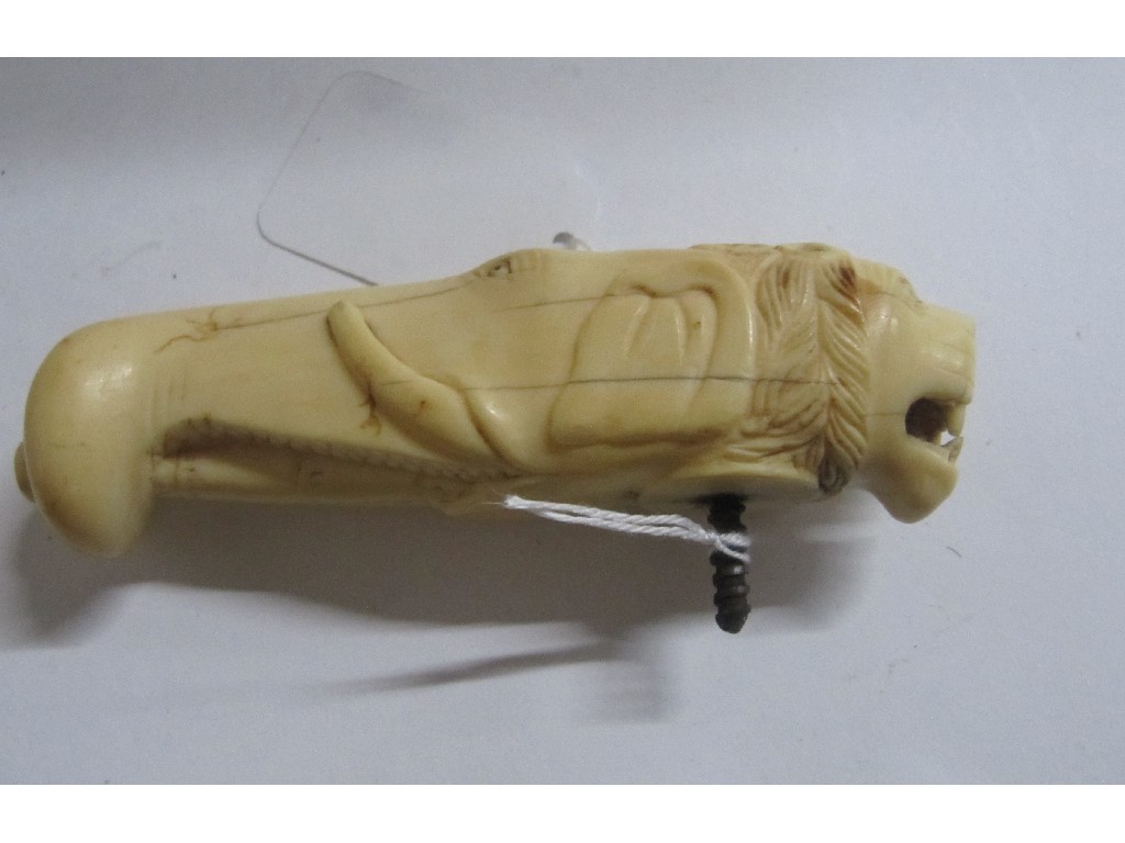 Appraisal: An ivory cane handle modelled as lion's and elephants's heads