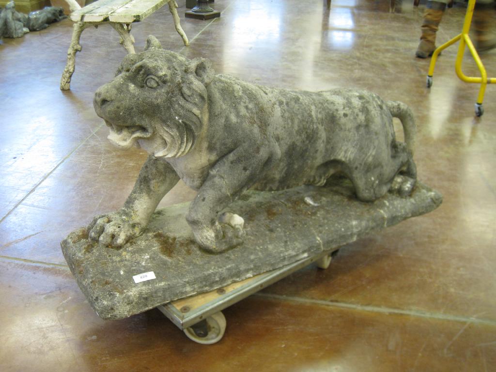 Appraisal: A simulated stone Lion on rectangular base ft in well