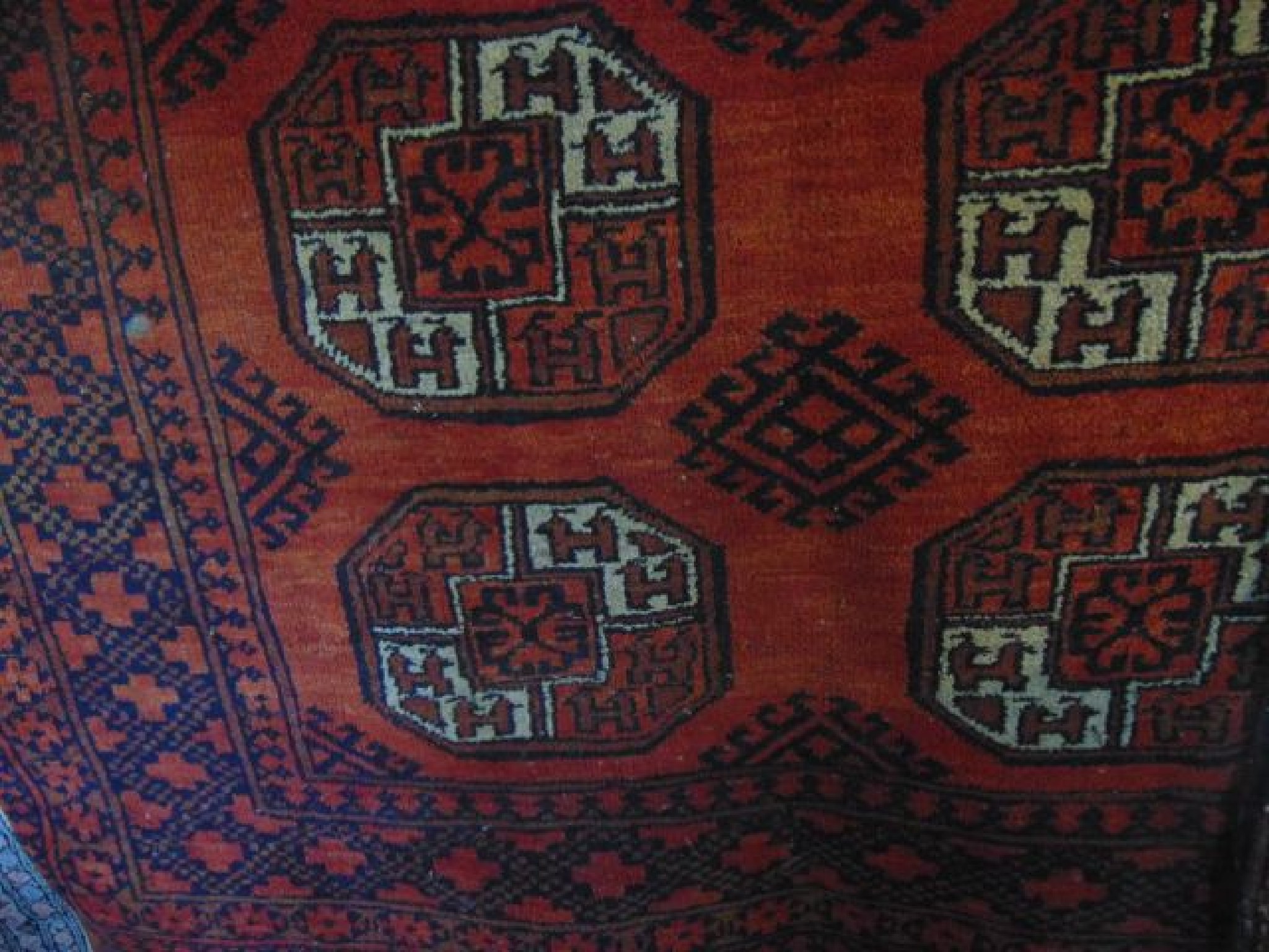 Appraisal: An Afghan red ground wool carpet with multi medallion centre