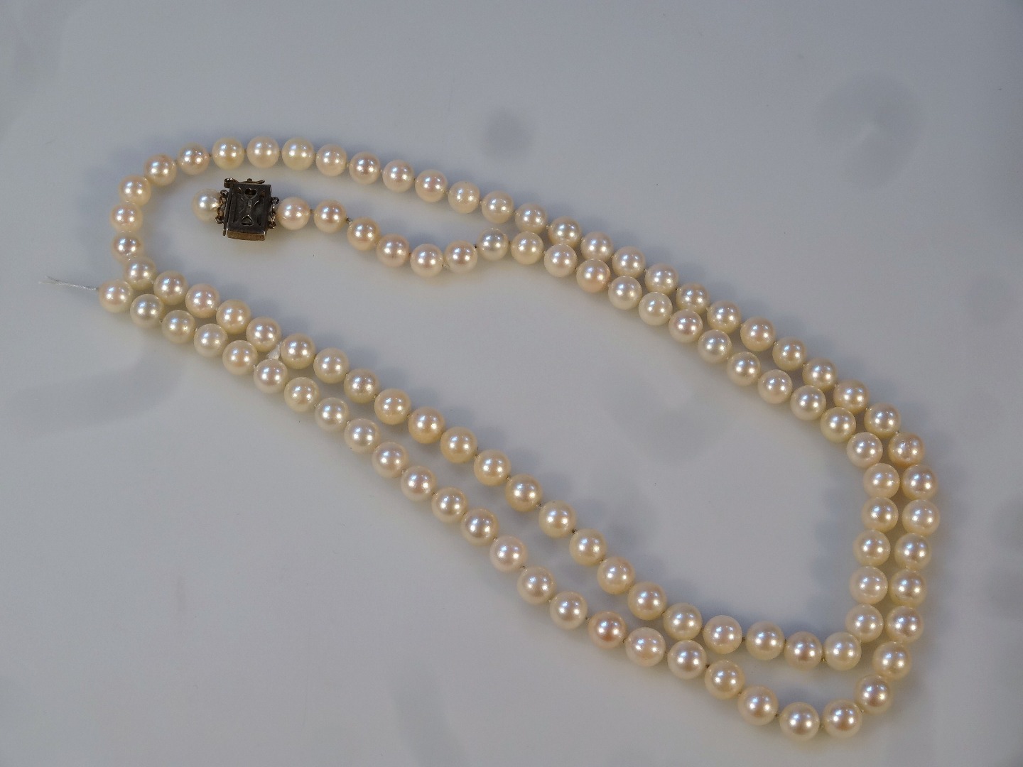 Appraisal: A cultured pearl necklace on plain string the clasp marked