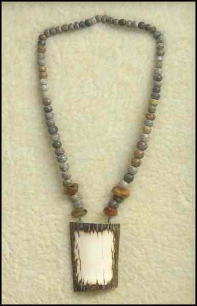 Appraisal: FRAMED TRIBAL NECKLACE Bone amber and stone Frame '' x