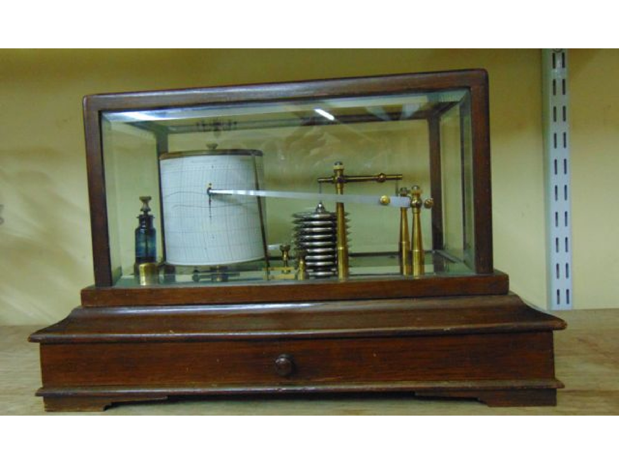 Appraisal: A barograph raised on an oak framework enclosing a frieze