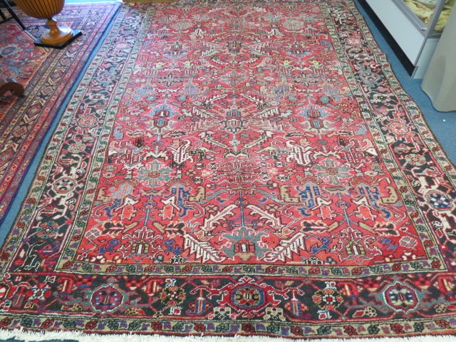 Appraisal: Heriz Persian Handmade Rug geometric floral designs red field '