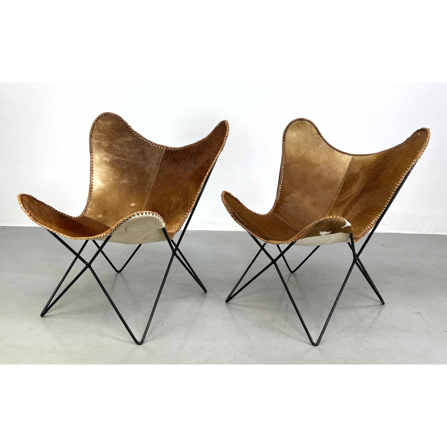 Appraisal: Pair of butterfly chairs with cowhide seat covers Hairpin Iron