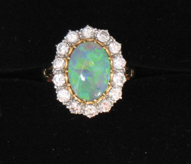 Appraisal: AN OPAL AND DIAMOND CLUSTER RING the large oval opal