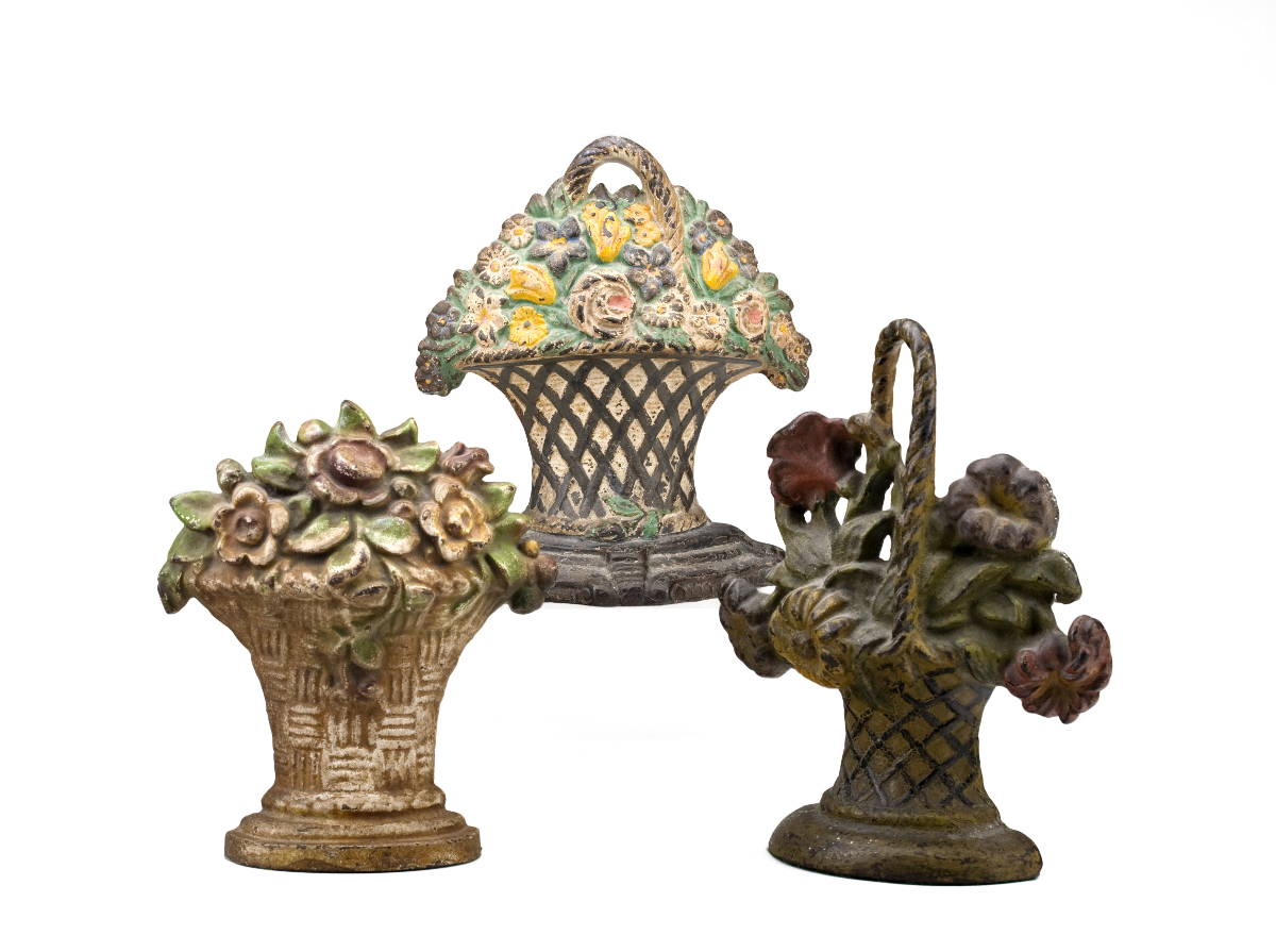 Appraisal: THREE CAST-IRON DOOR STOPS EACH IN THE FORM OF A