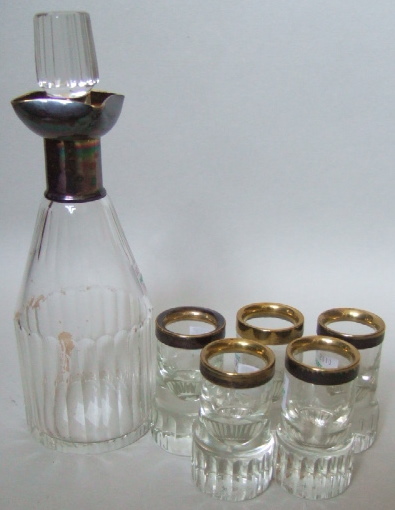 Appraisal: A plated metal mounted faceted glass liqueur decanter with fluted