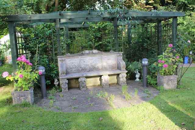 Appraisal: A PAIR OF CUBIC HADDONSTONE PLANTERS with ribbon tied floral