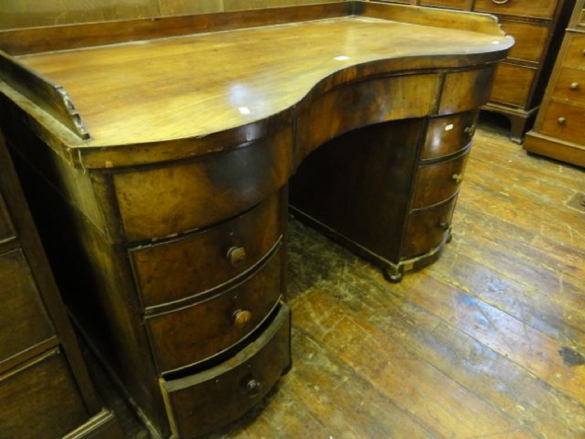 Appraisal: A th century mahogany serpentine front kneehole twin pedestal desk