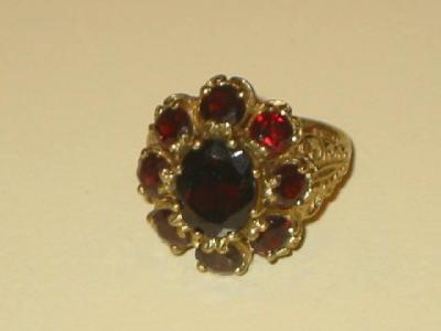 Appraisal: A GARNET DRESS RING the oval cut centre claw set