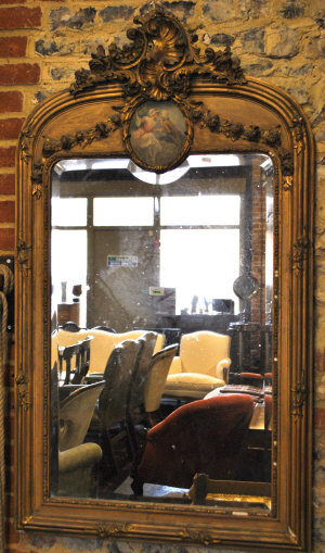 Appraisal: A French bevelled pier mirror surmounted by a floral and