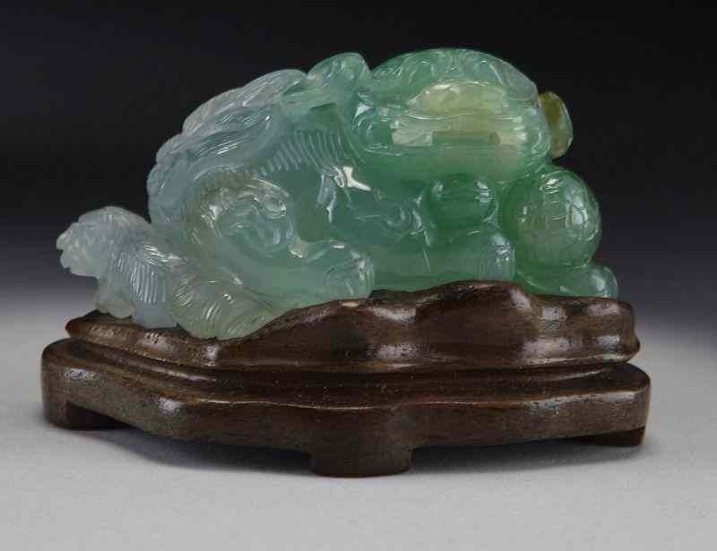 Appraisal: Chinese carved jadeite foo dog raised on a woodstand ''H