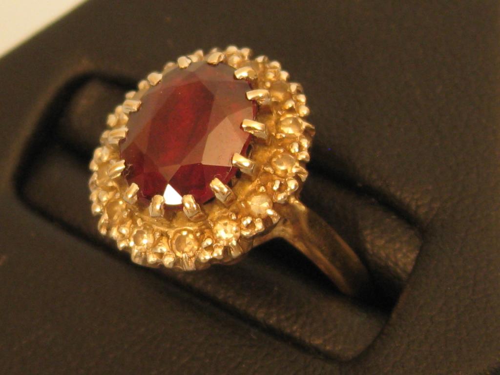 Appraisal: A Garnet and Diamond Ring the oval claw set garnet