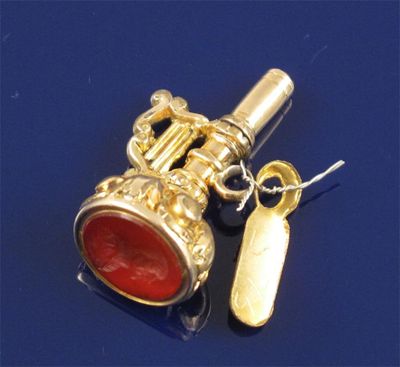 Appraisal: A small gold cased watch key cum seal With harp