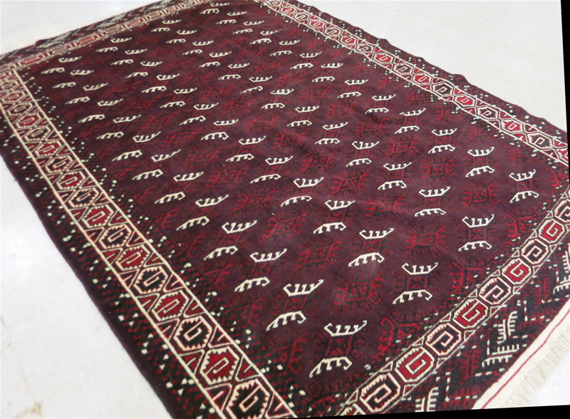 Appraisal: AN AFGHAN TURKOMAN CARPET repeating columns Turkoman gols on wine