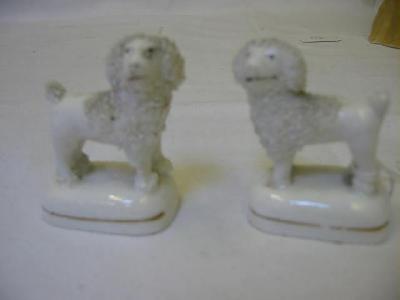 Appraisal: A PAIR OF STAFFORDSHIRE PORCELAIN POODLES modelled standing on rounded