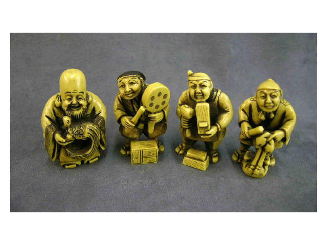 Appraisal: Four stained standing netsuke all inscribed including street entertainer holding